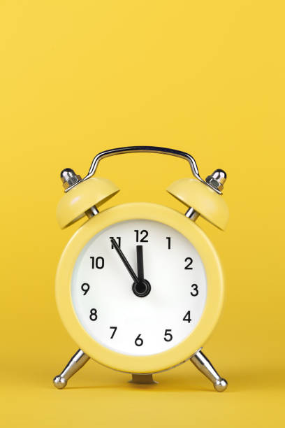 istock Yellow round alarm clock on the yellow background. 1191508581