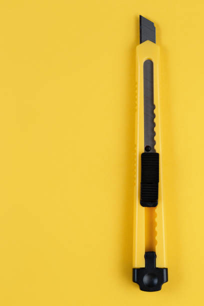 Yellow cutter knife on the yellow background