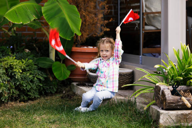 3 Years old girl sitting and holding Turkish Flags
