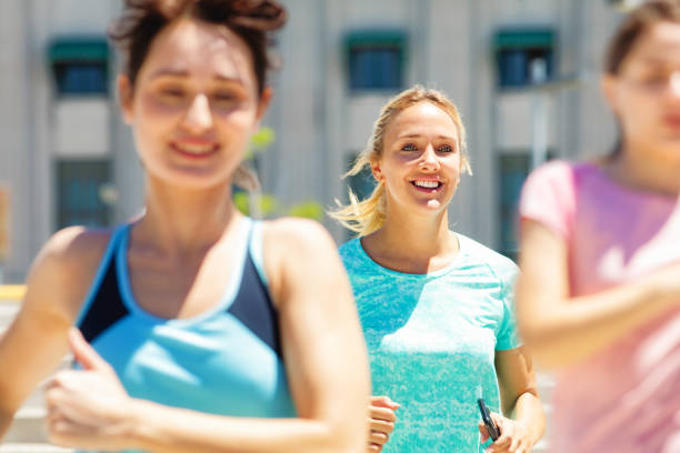 istock Vibrant young woman running in a group smiling 1191509462