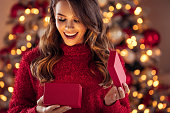 Beautiful girl sitting in a cozy atmosphere near the Christmas tree