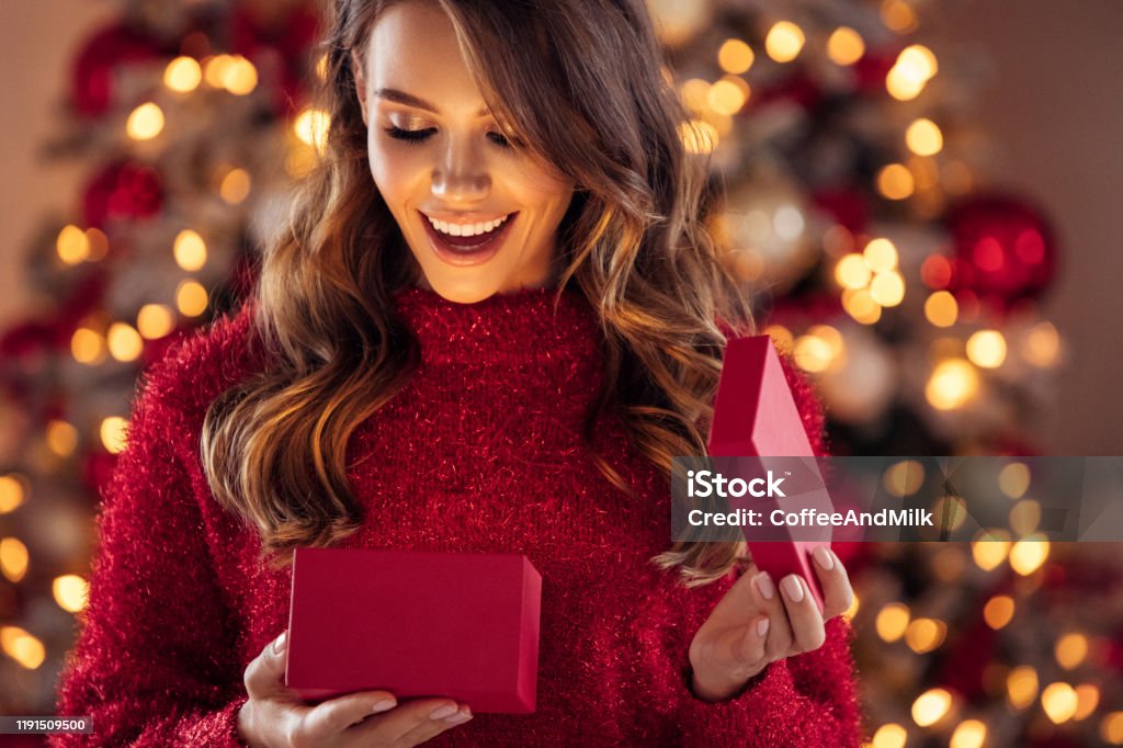 Beautiful girl sitting in a cozy atmosphere near the Christmas tree Christmas Stock Photo