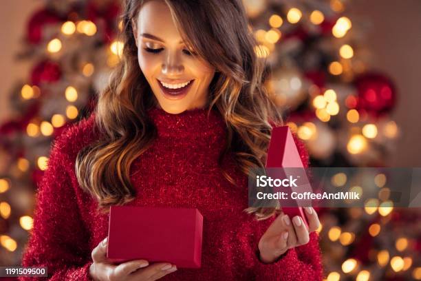 Beautiful Girl Sitting In A Cozy Atmosphere Near The Christmas Tree Stock Photo - Download Image Now