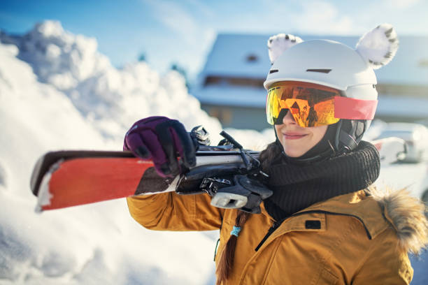 adolescente llevando esquís en un día de invierno - skiing snow skiing helmet fun fotografías e imágenes de stock