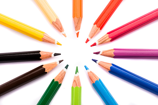 High angle view of colored circle shaped pencils in a row over white background