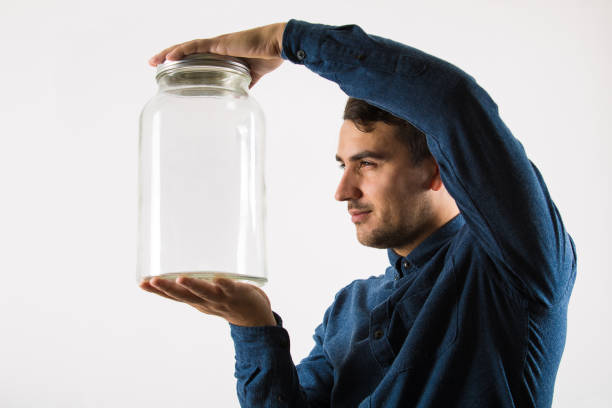 https://media.istockphoto.com/id/1191511442/photo/close-up-profile-portrait-of-a-curious-businessman-holding-an-empty-glass-jar-in-his-hands.jpg?s=612x612&w=0&k=20&c=Xl4hb817FnSoZSecNidOu2qoAmTRSHLiA6Ns3cux9to=