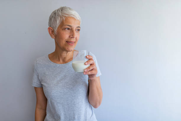 istock Cheerful mature woman having fun while drinking milk. 1191511733