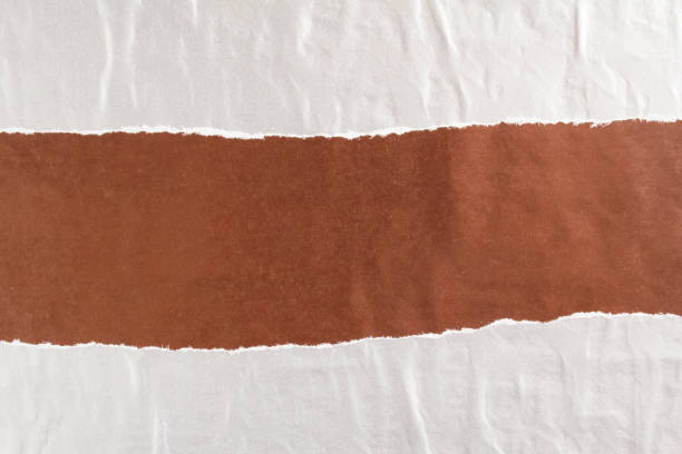 istock Dark brown and silver grey crumpled, torn and peeling gloss paper posters glued on rough surface texture background. Can be used for text. 1191512744