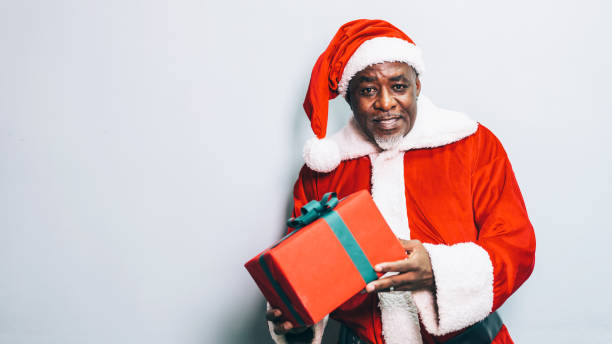 istock Santa Claus holding christmas gift on grey background 1191514511