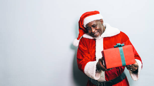 istock Santa Claus holding christmas gift on grey background 1191514533