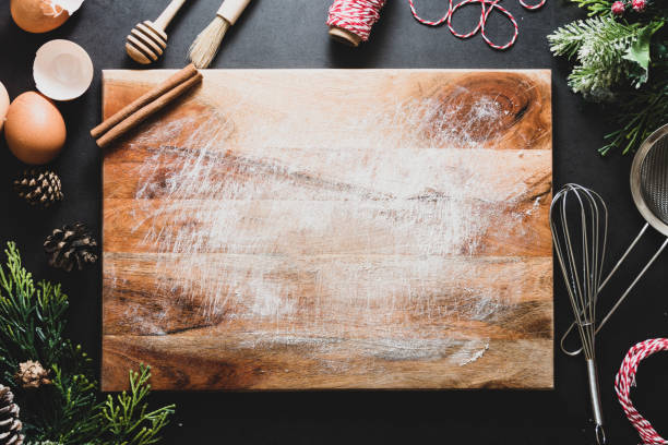 istock Christmas cooking or menu mock up. Empty cutting board and kitchen utensiles on dark background. Top view. Copy space. 1191514887