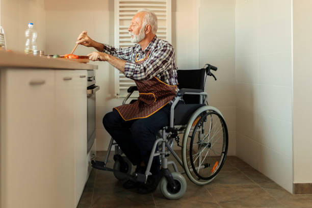 istock Man in Wheelchair Preparing Food 1191516621