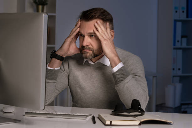 istock Serious and troubled office worker touching head in front of computer screen 1191520930