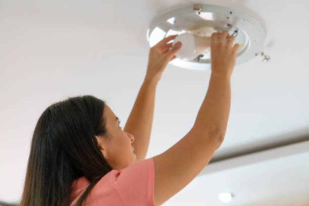 Woman Bulb replacement at home stock photo