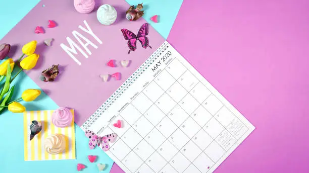 On-trend 2020 calendar page for the month of May modern flat lay with seasonal food, candy and colorful decorations in popular pastel colors. Copy space. One of a series for 12 months of the year.