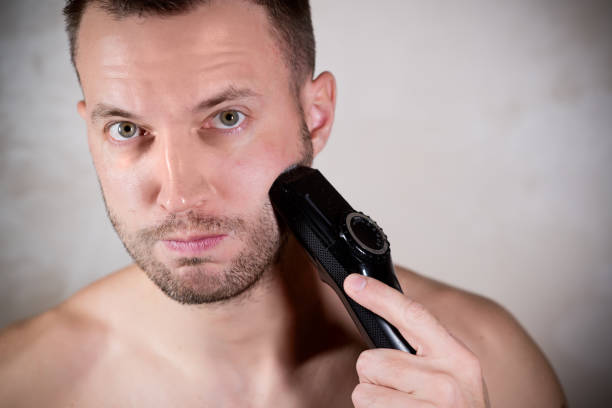 istock young man about to shave his short beard with a trimmer 1191528256