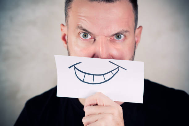 istock angry man covers his mouth with a sheet with a painted smile 1191528402