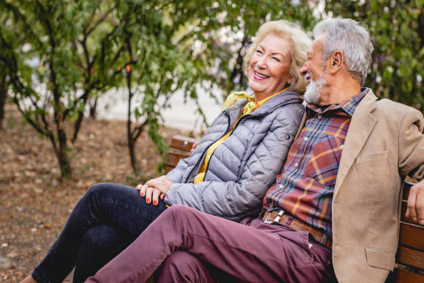 istock Senior Couple sitting on a bench in park 1191528711