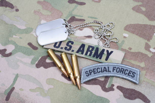 istock US ARMY special forces tab, flag patch, with dog tag and 5.56 mm rounds on camouflage uniform 1191531787