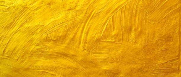 istock Roughly plastered wall texture background painted with gold paint 1191532421