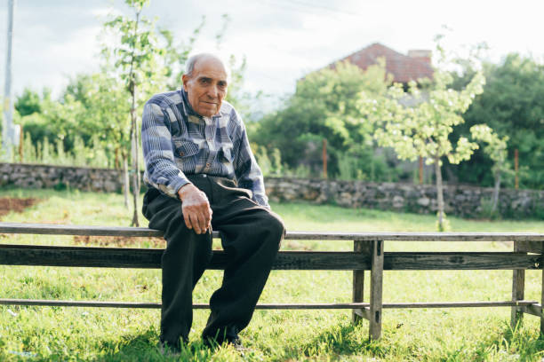 istock Elderly man sitting on bench outdoors 1191532673
