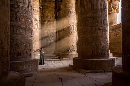 Abydos, Egypt - November 07, 2018 :  \nThe guardian of the temple captured as he contemplates the rays of light that enters the temples through the openings of the walls.