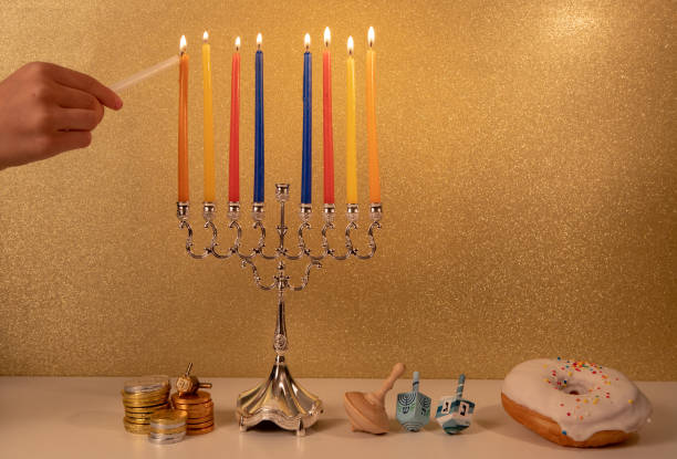 festa religiosa ebraica hanukkah con la mano del bambino che accende l'ultima, 8a candela nel lampadario tradizionale menorah - hanukkah menorah human hand lighting equipment foto e immagini stock