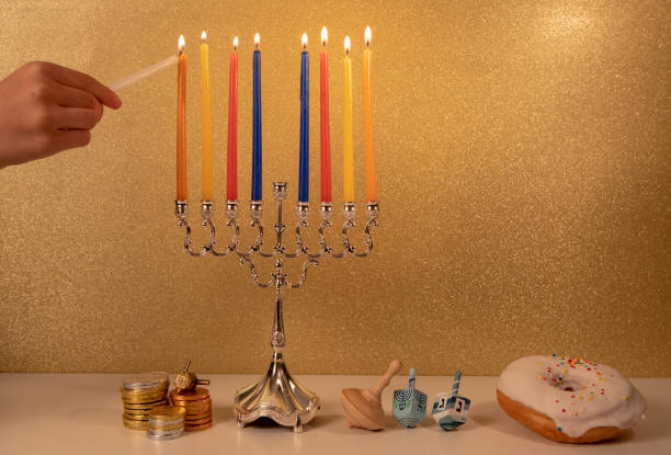 feriado religioso judaico hanukkah com a mão da criança que ilumina a última, 8a vela no menorah tradicional do candelabro - hanukkah menorah human hand lighting equipment - fotografias e filmes do acervo