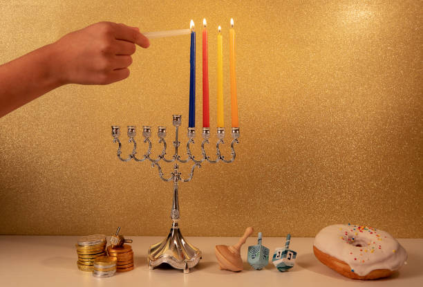 伝統的なシャンデリアメノラで子供の手の照明第4�キャンドルとユダヤ教の宗教的な休日ハヌカ - menorah hanukkah candle human hand ストックフォトと画像