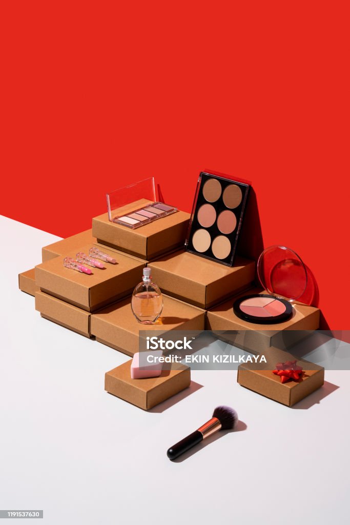 Gift boxes and makeup accessories organized neatly on red and white background Kraft paper gift boxes and makeup accessories flat lay on red and white background Make-Up Stock Photo