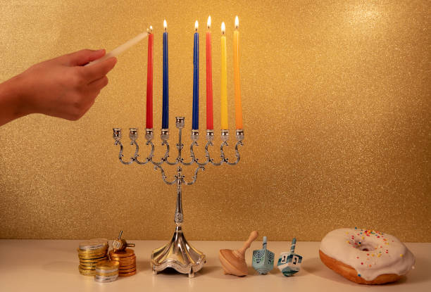 festa religiosa ebraica hanukkah con la mano del bambino che accende la 6a candela nel lampadario tradizionale menorah - hanukkah menorah human hand lighting equipment foto e immagini stock