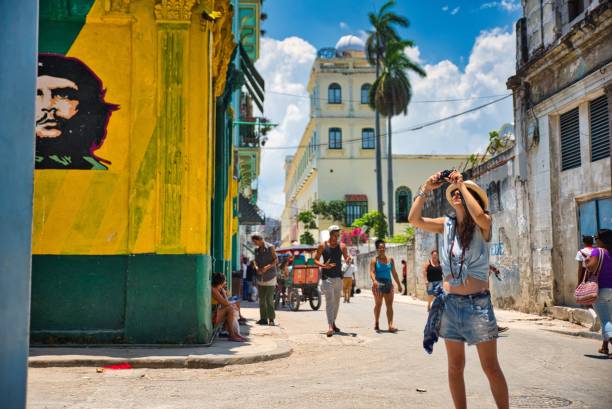 Havana, Cuba - May 12, 2015: Beautiful colored graffiti with Che Guevara image on the wall and a woman tourist taking photos of the buildings in Old Havana, Cuba.