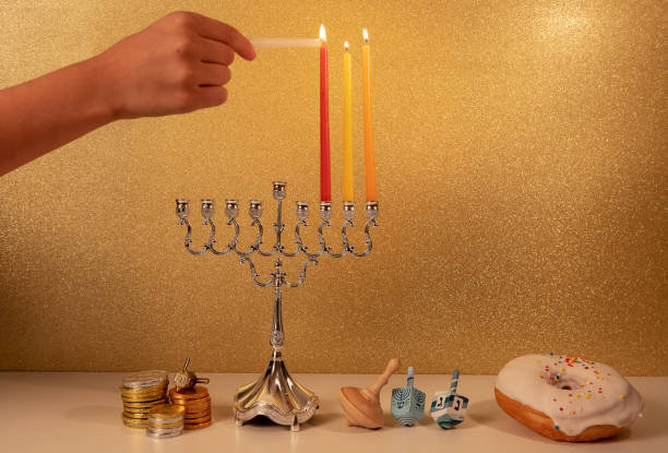 伝統的なシ�ャンデリアメノラで子供の手の照明第3キャンドルとユダヤ教の宗教的な休日ハヌカ - menorah hanukkah candle human hand ストックフォトと画像