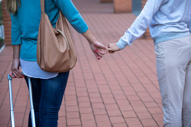 istock Close-up of two unknown woman holding hands 1191539191