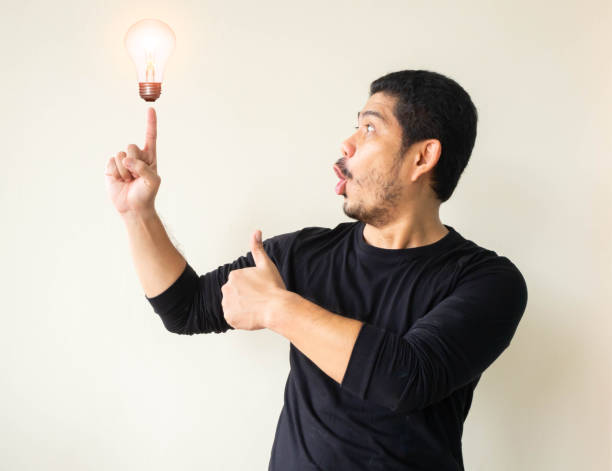 istock Excited man pointing up with a new idea, Smiling young Asian man looking and pointing up, Smiling young Asian man pointing his index finger up. 1191540904