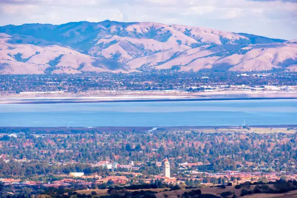 Photo of Aerial view of Stanford University amd Palo Alto, San Francisco Bay Area; Newark and Fremont and the Diablo mountain range visible on the other side of the bay; Silicon Valley, California