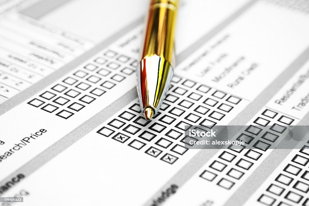 Close-up of gold pen on top of a survey sheet Close up of business survey Application Form Stock Photo