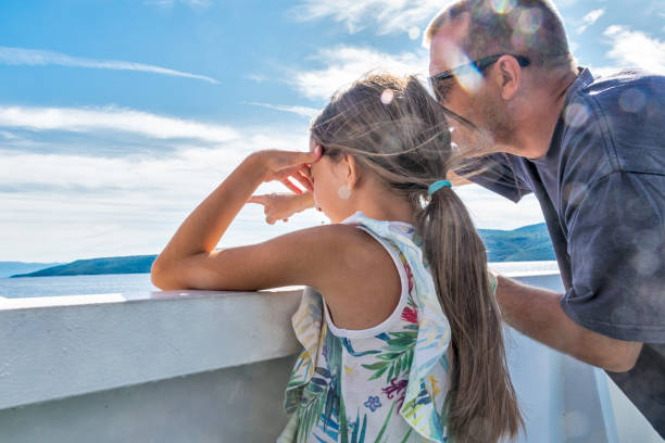 Daughter and Father Enjoy on the Ferry Boat Deck in Sunny Day Traveling on Vacation Daughter and Father Enjoy on the Ferry Boat Deck in Sunny Day Traveling on Vacation ferry deck girls stock pictures, royalty-free photos & images
