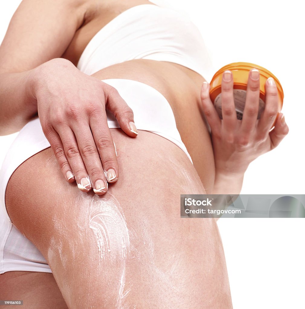 Young woman applying moisturiser on leg.  Buttocks Stock Photo