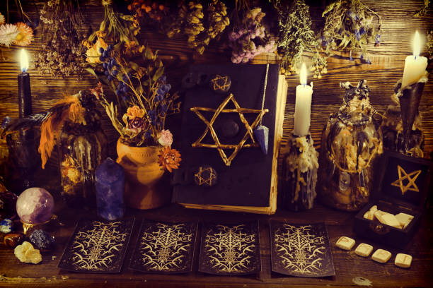 istock Creepy witch book with pentagram, tarot cards, runes, gemstone, candle and magic objects. 1191563102