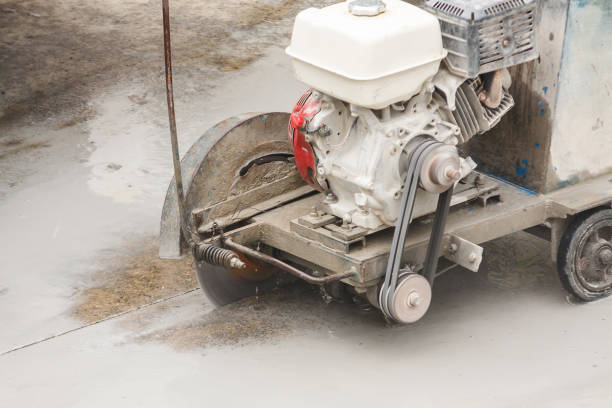 istock Worker using diamond saw blade machine cutting concrete road at construction site 1191566040