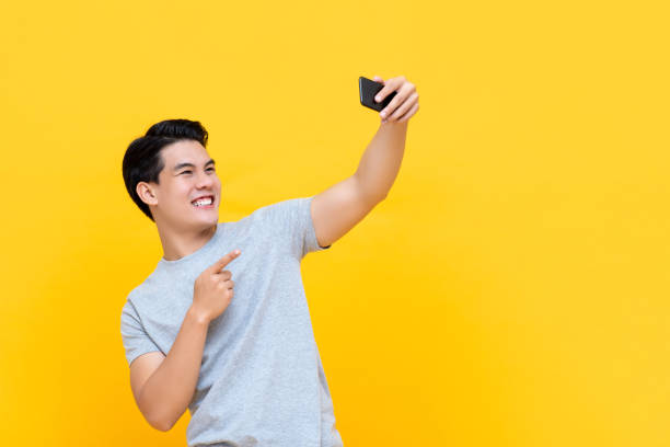 istock Young smiling handsome Asian man taking selfie with smartphone 1191566141