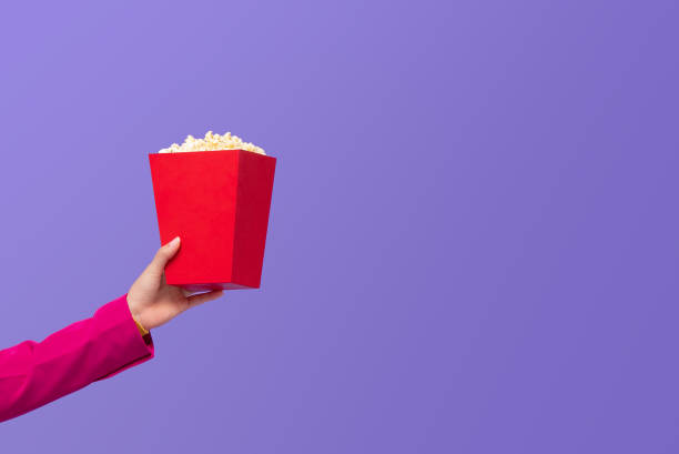 Woman hand giving popcorn in red box