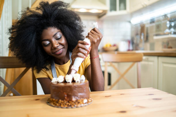 istock African woman preparing cake at home, decorating 1191566385