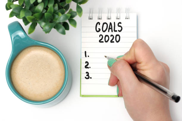 istock Female hand writes Goals 2020 in a notebook, planning concept 1191571584
