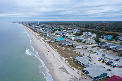 Aerial view of the beach front at Oak Island NC. Out over the water, looking back at the beach front and waves crashing.