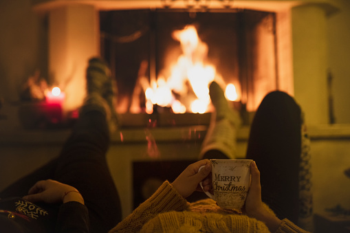 Couple resting by the Christmas fireplace.