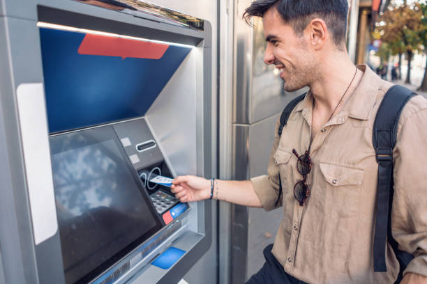 istock Man using the ATM device on the street 1191574361