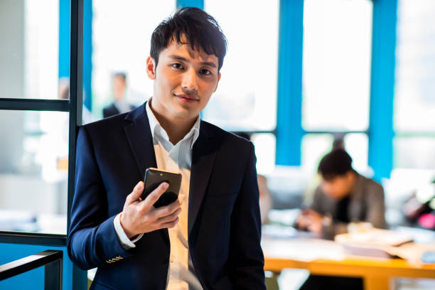 un hombre de negocios asiático te sonríe - telephone dialing human hand office fotografías e imágenes de stock