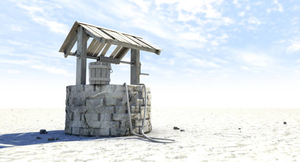 Well On Waterless Landscape A rundown water well and bucket attached to a rope in a flat waterless landscape on a blue sky background - 3D render waterless stock pictures, royalty-free photos & images